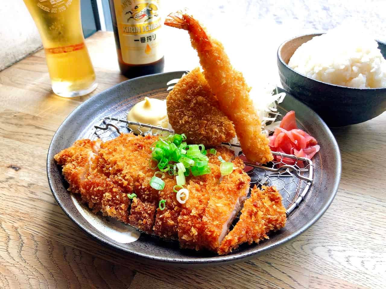 Japanese food tonkatsu, a breaded deep-fried pork cutlet, sliced into strips with shredded cabbage, fried shrimp and pumpkin