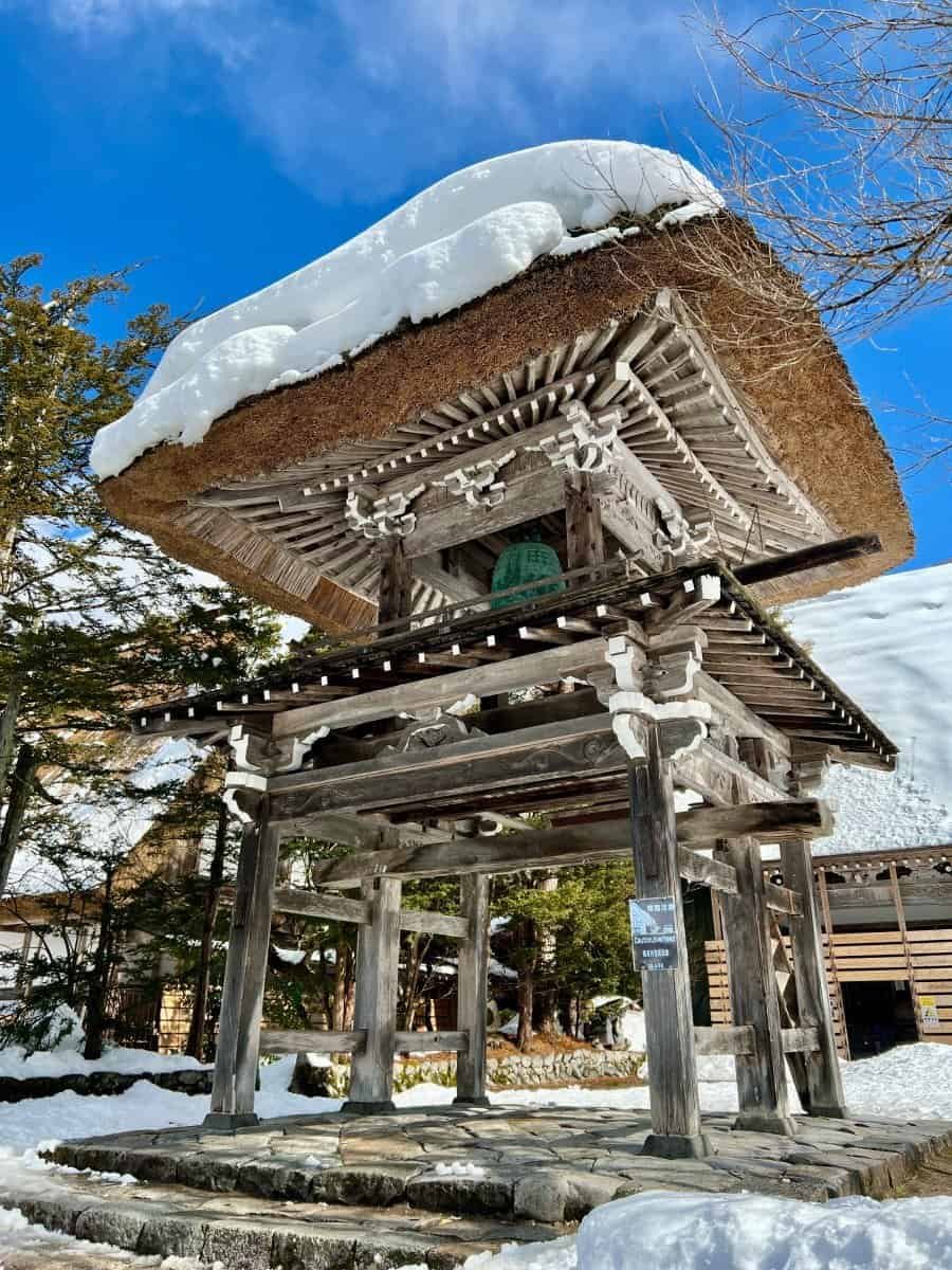 The unique thatched-roof Shoro bell tower gate at Myozenji Temple in Ogimachi village.