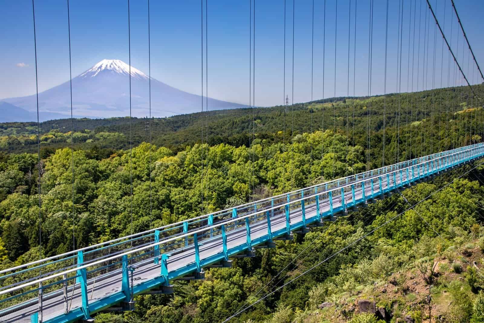 Mishima Skywalk suspension bridge with Mount Fuji in the background on a clear day